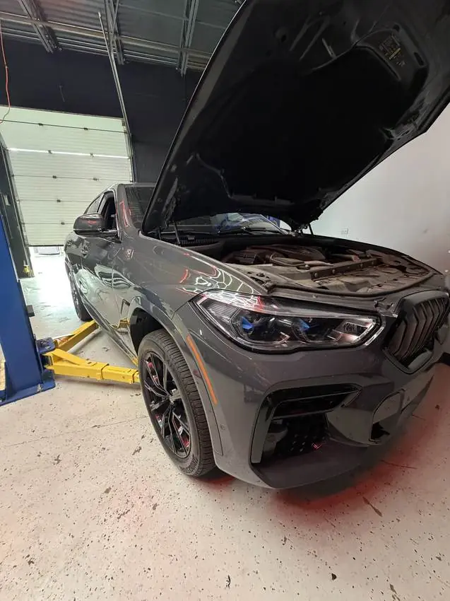 BMW X M with the hood open for diagnostics at PRM Eurowerks